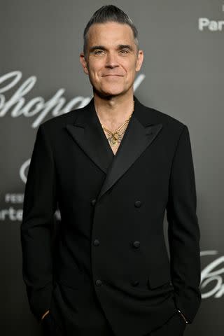 <p>Lionel Hahn/Getty</p> Robbie Williams attends the 76th annual Cannes Film Festival