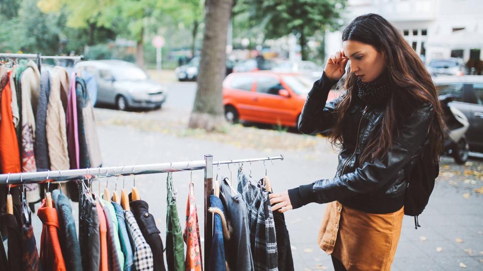 Vintage toned portrait of a young woman in Berlin, wearing a black leather jacket and a beige skirt, walking down the street in Berlin  Kreuzberg district in the late Autumn day, shopping on the street market.