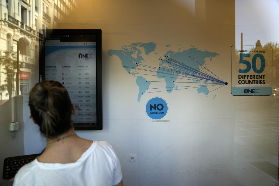 An employee adds the currency at an exchange office at Syntagma square in Athens, Greece, Wednesday, July 13, 2022. The euro on Tuesday fell to parity with the dollar for the first time in nearly 20 years. (AP Photo/Thanassis Stavrakis)