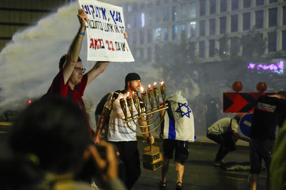 Police use water cannon to disperse demonstrators during a protest against Israeli Prime Minister Benjamin Netanyahu's government, and calling for the release of hostages held in the Gaza Strip by the Hamas militant group, in Tel Aviv, Israel, Saturday, May 11, 2024. (AP Photo/Ariel Schalit)
