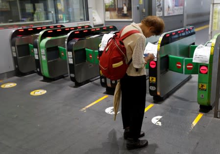 A passenger waits for the resumption of train service in a snarl caused by Typhoon Faxai at Komagome station in Tokyo