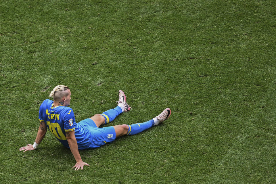 Ukraine's Mychajlo Mudryk sits on the pitch after a Group E match between Romania and Ukraine at the Euro 2024 soccer tournament in Munich, Germany, Monday, June 17, 2024. (Sven Hoppe/dpa via AP)