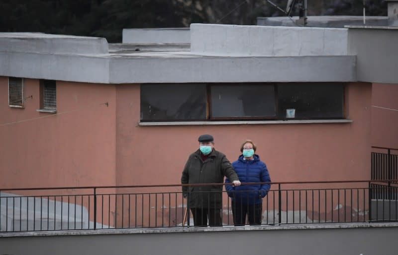 People listen to the music, as DJ Francesco Cellini plays for them from the rooftop terrace, as Italians remain under lockdown to prevent the spread of coronavirus disease (COVID-19) in Monteverde district, Rome