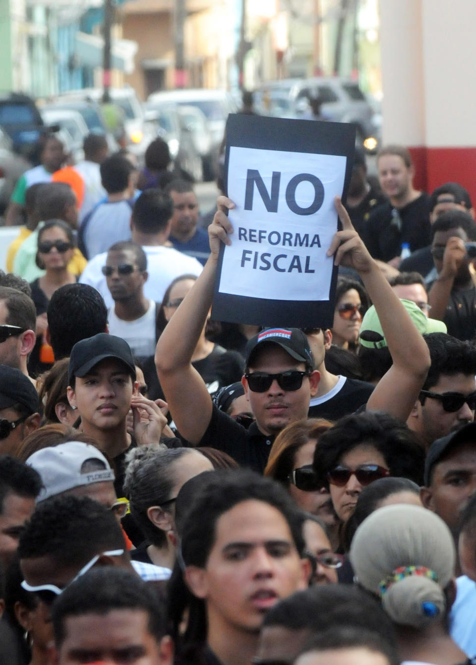 Dominicans attend a demonstration against the fiscal reform in Santo Domingo, Dominican Republic, Sunday, Nov. 11, 2012. Hundreds of Dominicans protested against the government of Danilo Medina who presented to Congress the disputed tax legislation as a way to help close the $4.6 billion deficit in the government's budget. The measure will increase the general sales tax to 18 percent from 16 percent, will raise the price of gasoline and impose taxes on basic food products. The sign reads in Spanish: "No to fiscal reform". (AP Photo/Manuel Diaz)