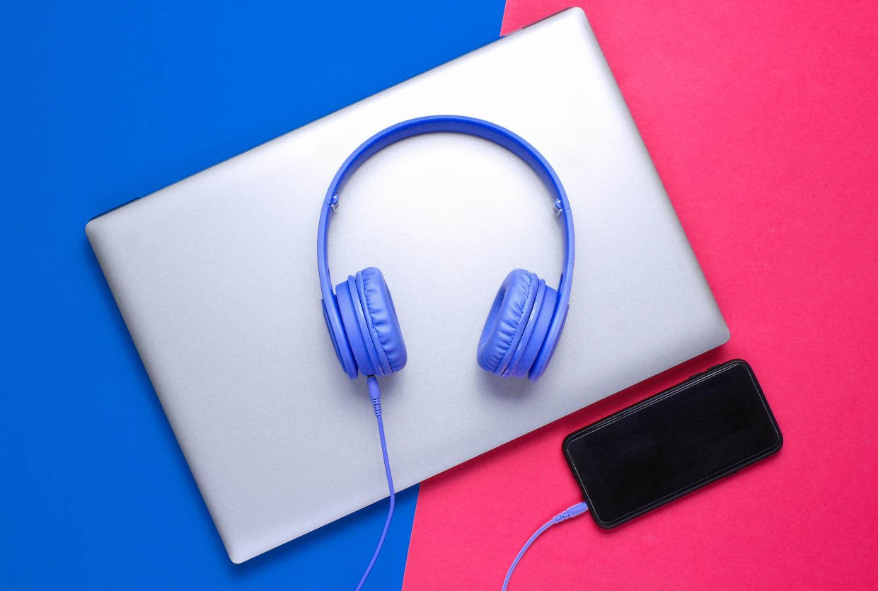 Modern gadgets. Laptop, headphones, smartphone on blue red background. Top view. Flat lay