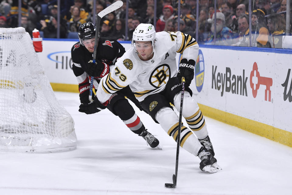 Boston Bruins defenseman Charlie McAvoy, right, shields the puck from Buffalo Sabres center Casey Mittelstadt during the second period of an NHL hockey game in Buffalo, N.Y., Wednesday, Dec. 27, 2023. (AP Photo/Adrian Kraus)