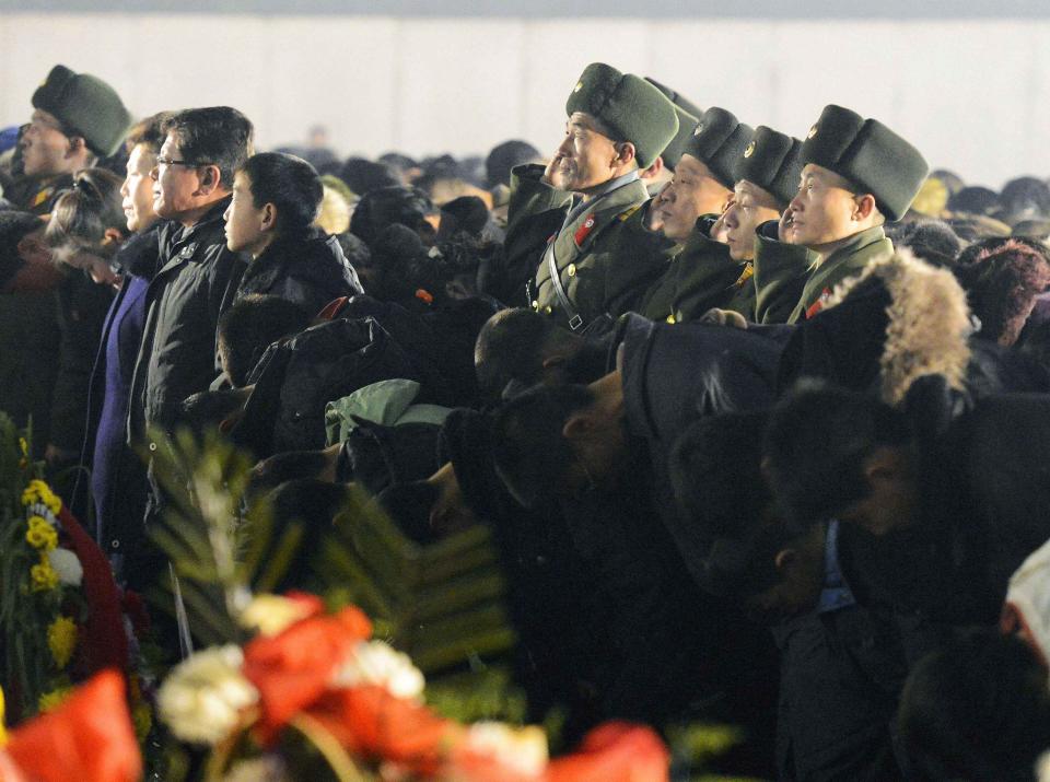 North Korean soldiers salute as civilians bow to bronze statues of North Korea's late founder Kim Il Sung and late leader Kim Jong Il at Mansudae in Pyongyang