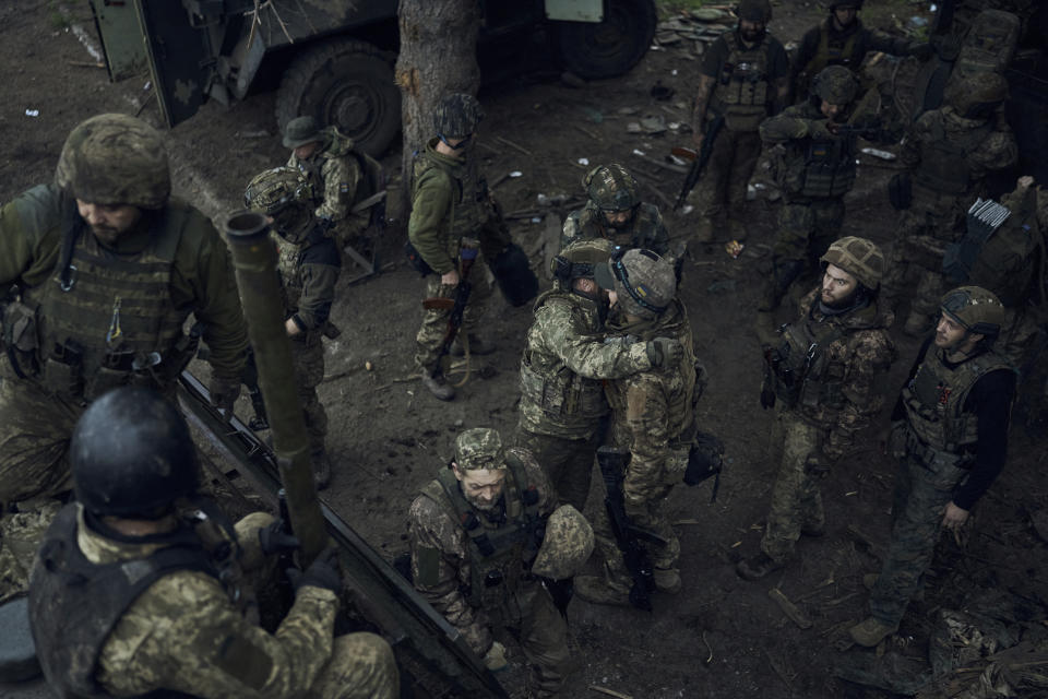 Ukrainian soldiers hug as they go to have some rest at the frontline near Bakhmut in the Donetsk region, Ukraine, Saturday, May 27, 2023. (AP Photo/Libkos)