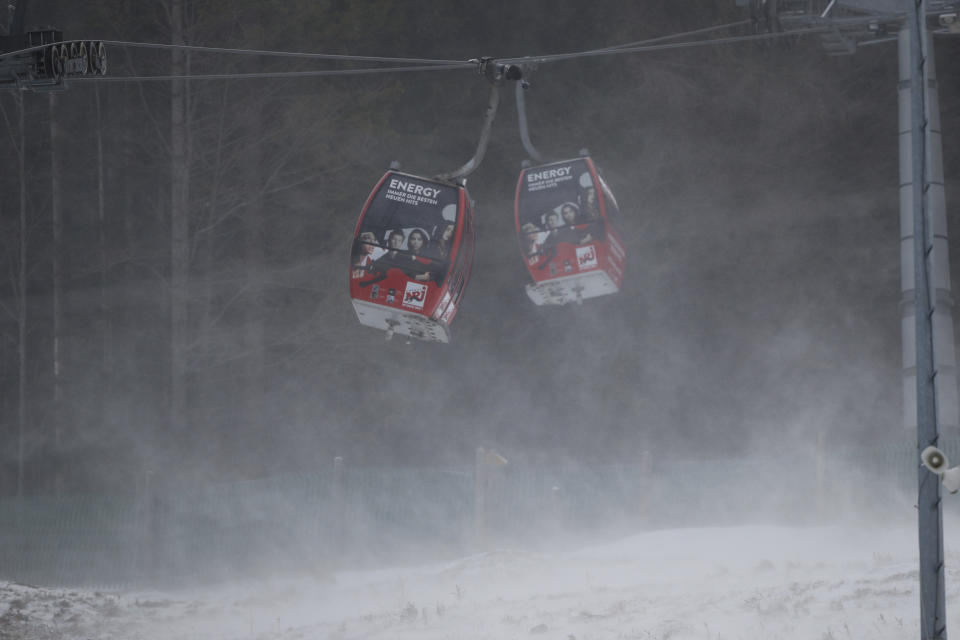 Cable cars are blown by strong winds during a pause of an alpine ski, women's World Cup giant slalom, in Semmering, Austria, Monday, Dec. 28, 2020. (AP Photo/Gabriele Facciotti)