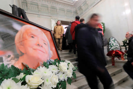 People walk past a picture of the founder of Russia's oldest human rights group and Sakharov Prize winner, Lyudmila Alexeyeva, during her memorial service in Moscow, Russia December 11, 2018. REUTERS/Maxim Shemetov
