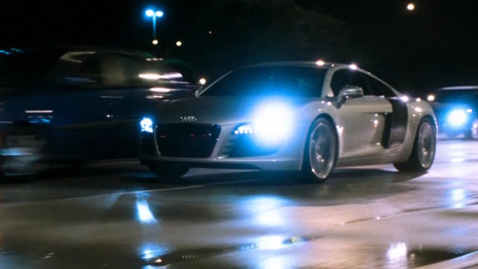 Tony Stark rides his silver Audi R8 through traffic in Iron Man