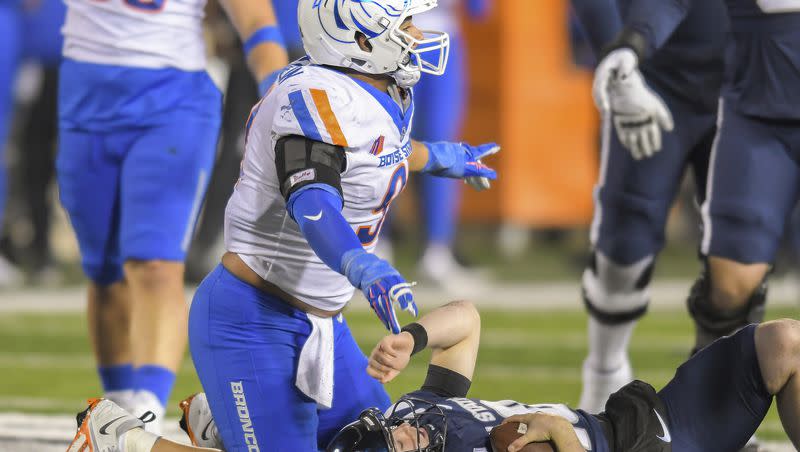 Boise State defensive end Ahmed Hassanein, left, celebrates after sacking Utah State quarterback McCae Hillstead, right, in the first half of an NCAA college football game Saturday, Nov. 18, 2023, in Logan, Utah.