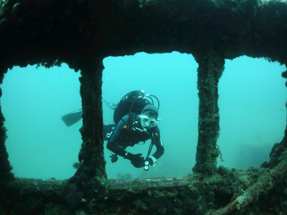 A scuba diver explores a shipwreck in Rovinj, Croatia.