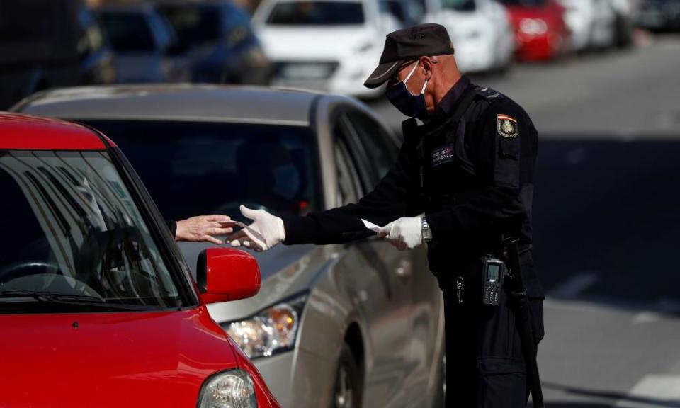 A police officer checks the papers of a driver in Spain