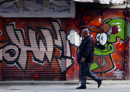 A man walks in front of a graffiti painted on the wall of a building located inside the 15th-century complex built by Mameluk Sultan al-Ashraf Qaitbey, in Cairo's City of the Dead, Egypt February 13, 2017. REUTERS/Amr Abdallah Dalsh