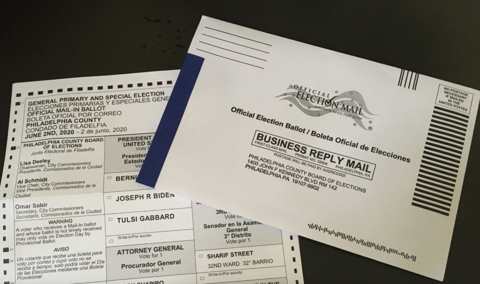 A mail-in election ballot partially obscured by its envelope