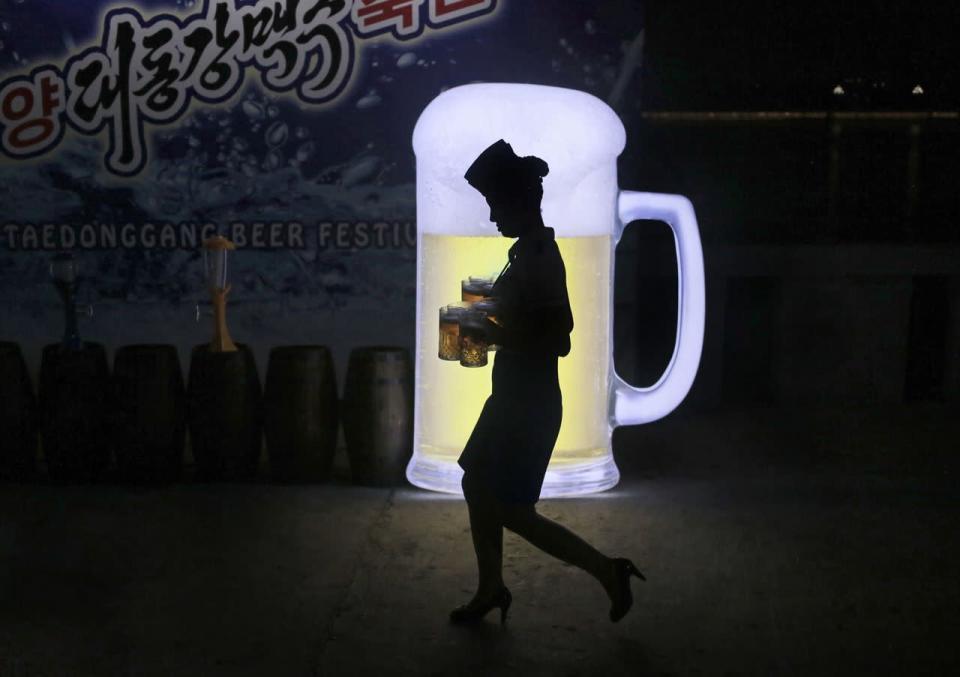 Eine Kellnerin trägt volle Biergläser während der ersten Ausgabe des Bier-Festivals „Taedonggang“ in der nordkoreanischen Stadt Pjöngjang. (Bild: Dita Alangkara/AP)