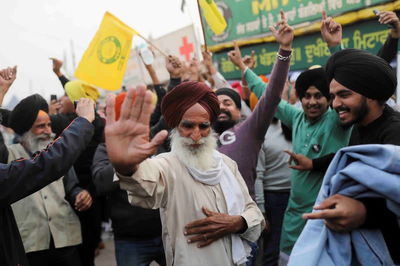 Farmers celebrate after Prime Minister Narendra Modi announced that he will repeal the controversial farm laws, at the Singhu border farmers protest site near Delhi-Haryana border