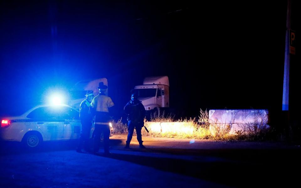 Russian police officers block a road to the site of the plane crash near the village of Kuzhenkino, Tver region, Russia