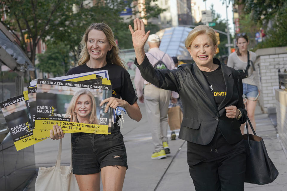 Rep. Carolyn Maloney waves while her daughter Virginia holds campaign posters.