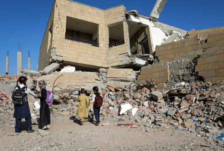 Yemeni children walk outside a school on March 16, 2017 that was damaged in an air strike in the southern city of Taez