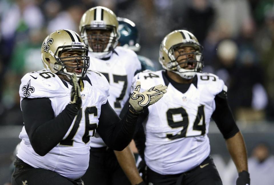 New Orleans Saints' Akiem Hicks (76) and Cameron Jordan (94) celebrate after tackling Philadelphia Eagles' Nick Foles during the second half of an NFL wild-card playoff football game, Saturday, Jan. 4, 2014, in Philadelphia. (AP Photo/Michael Perez)