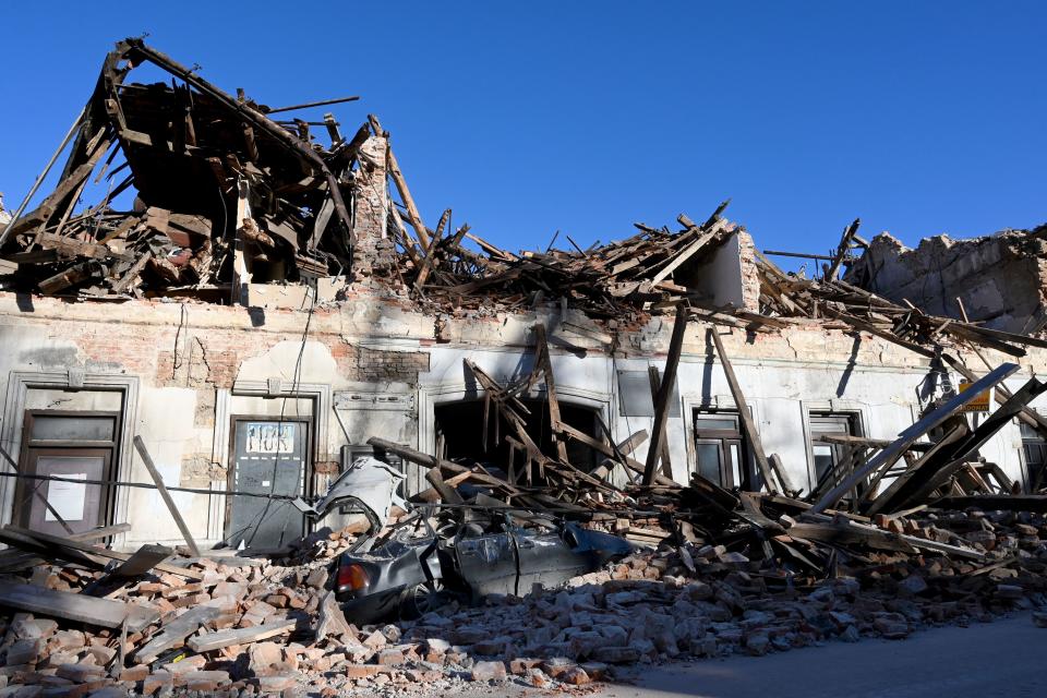 This photograph taken on December 29, 2020, shows the wreckage of a car and damaged buildings in Petrinja, some 50kms from Zagreb, after the town was hit by an earthquake of the magnitude of 6.4. - The tremor, one of the strongest to rock Croatia in recent years, collapsed rooftops in Petrinja, home to some 20,000 people, and left the streets strewn with bricks and other debris. Rescue workers and the army were deployed to search for trapped residents, as a girl was reported dead. (Photo by DENIS LOVROVIC / AFP) (Photo by DENIS LOVROVIC/AFP via Getty Images)