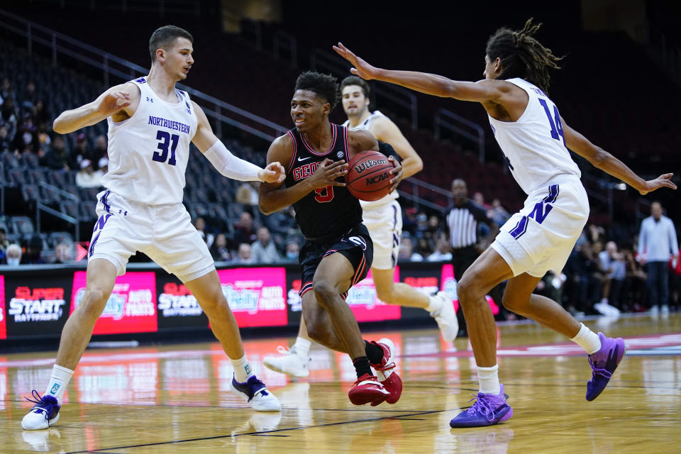 Georgia's Christian Wright (5) drives past Northwestern's Robbie Beran (31) and Casey Simmons (14) during the first half of an NCAA college basketball game Tuesday, Nov. 23, 2021, in Newark, N.J. (AP Photo/Frank Franklin II)