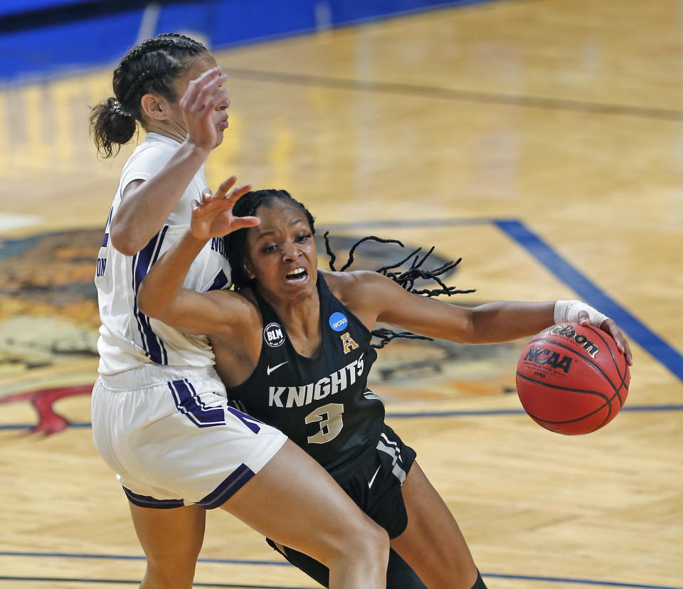 CORRECTS TO MONDAY, MARCH 22, 2021-UCF guard Diamond Battles (3) drives on Northwestern guard Veronica Burton (12) during the first half of a college basketball game in the first round of the women's NCAA tournament at the Greehey Arena in San Antonio, Texas, Monday, March 22, 2021. (AP Photo/Ronald Cortes)