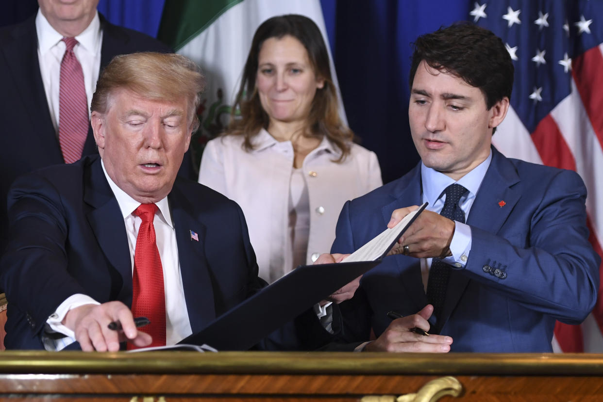 US President Donald Trump (L) and Canadian Prime Minister Justin Trudeau (R) along with Mexico's President Enrique Pena Nieto (out of frame) changes documents after signing a new free trade agreement in Buenos Aires, on November 30, 2018, on the sidelines of the G20 Leaders' Summit. - The revamped accord, called the US-Mexico-Canada Agreement (USMCA), looks a lot like the one it replaces. But enough has been tweaked for Trump to declare victory on behalf of the US workers he claims were cheated by NAFTA. (Photo by SAUL LOEB / AFP)        (Photo credit should read SAUL LOEB/AFP/Getty Images)