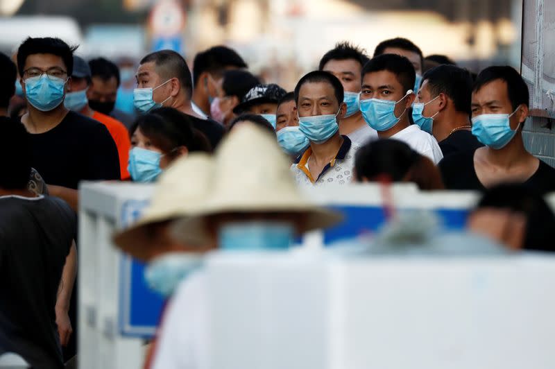 People are wearing face masks inside the Jingshen seafood market which has been closed for business after new coronavirus infections were detected, in Beijing
