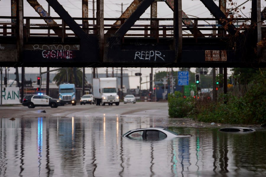 Cars are submerged on a flooded street under a railroad bridge Thursday, Feb. 1, 2024 in Long Beach, Calif. Heavy rain flooded roadways and much-needed snow piled up in the mountains on Thursday as the first of back-to-back atmospheric rivers pummeled California. (AP Photo/Eric Thayer)