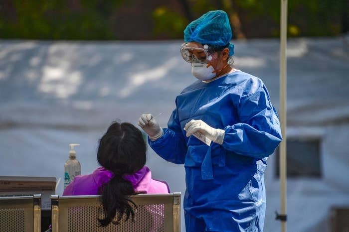 A medical professional administering a nasal swab Covid-19 test outside