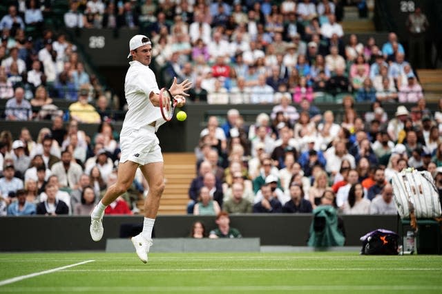 Tommy Paul jumps to hit a backhand