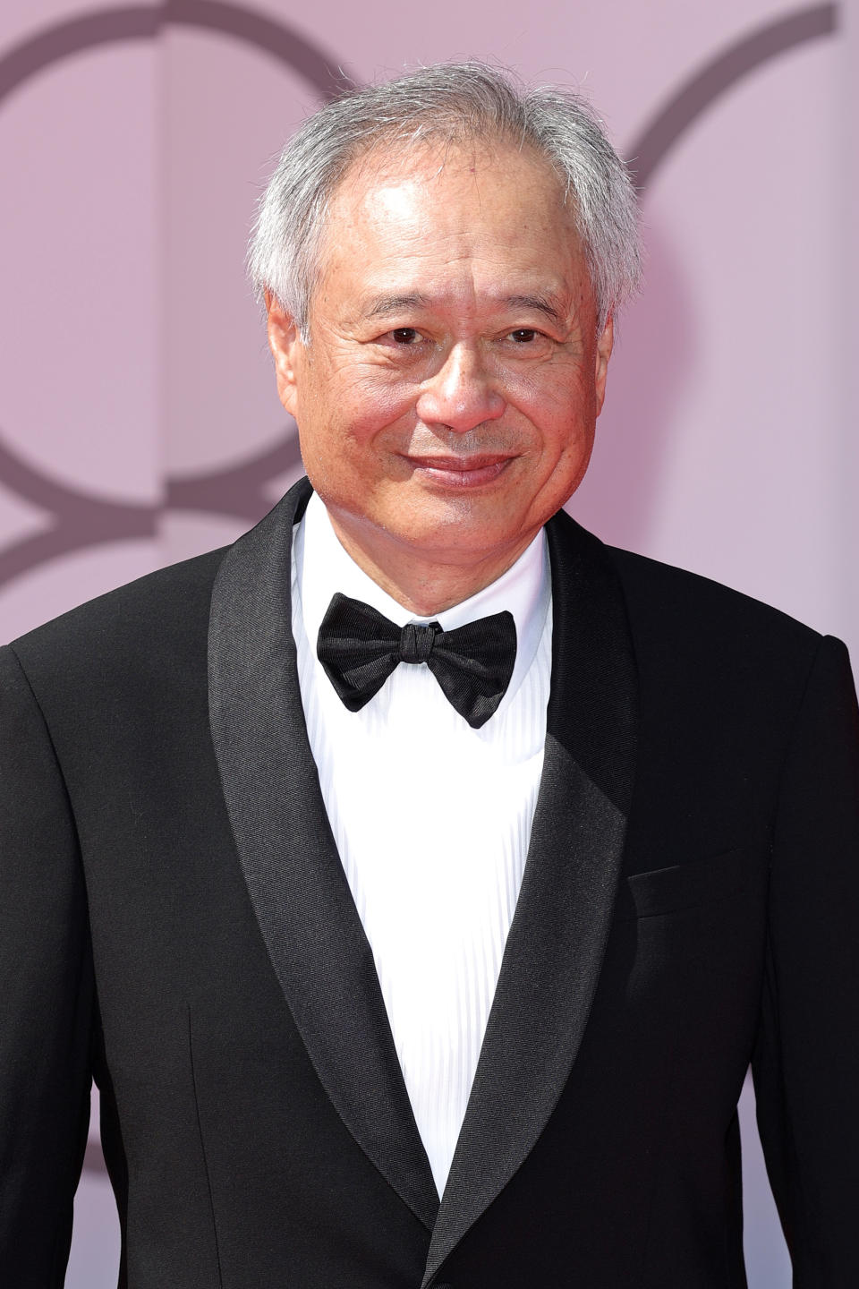 Ang Lee in a black tuxedo with a bow tie at a red carpet event