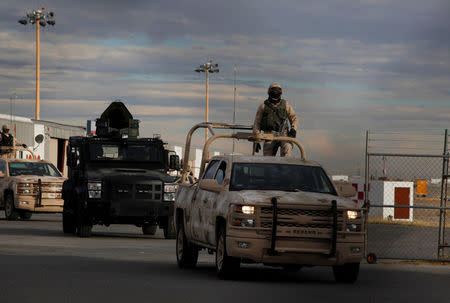 Military trucks and an armoured vehicle drive at a private landing strip, as signs of increased security are seen next to the international airport in Ciudad Juarez, Mexico, January 19, 2017. REUTERS/Jose Luis Gonzalez
