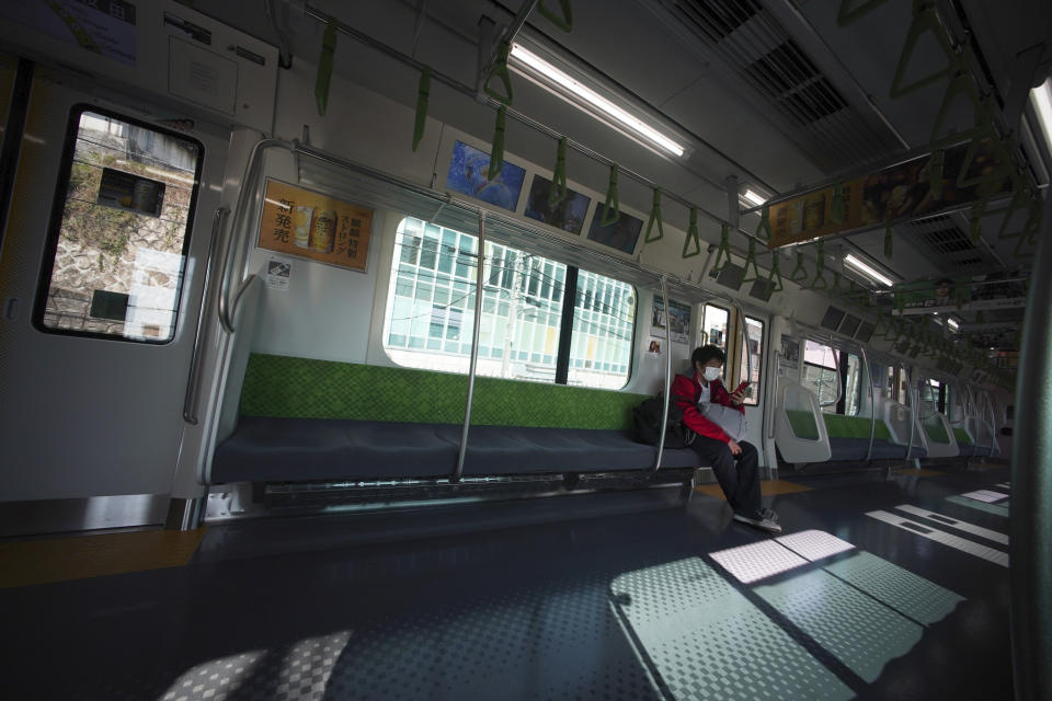 A man with protective mask rides an empty train Wednesday, April 8, 2020, in Tokyo. Japanese Prime Minister Shinzo Abe declared a state of emergency yesterday for Tokyo and six other prefectures to ramp up defenses against the spread of the coronavirus. (AP Photo/Eugene Hoshiko)