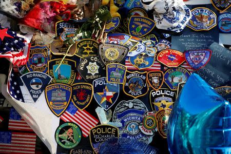Police patches from around the United States are pictured at a makeshift memorial at police Headquarters following the multiple police shootings in Dallas, Texas, U.S., July 13, 2016. REUTERS/Carlo Allegri