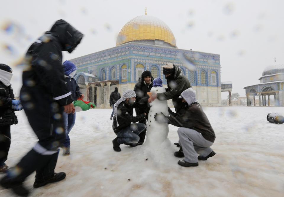 People build a snowman in front of the Dome of the Rock in Jerusalem's Old City