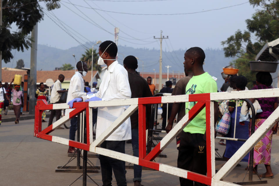 Medical personnel check people at the Congo side of the Poids Lourd checkpoint at the border between Congo and Rwanda, Thursday, Aug. 1, 2019. Congo's presidency says the border is open again with Rwanda hours after its eastern neighbor closed it over the deadly Ebola outbreak. The closure occurred Thursday morning as the first case of direct transmission of the Ebola virus was confirmed in Goma, the Congo city of more than 2 million people on the Rwandan border.(AP Photo)