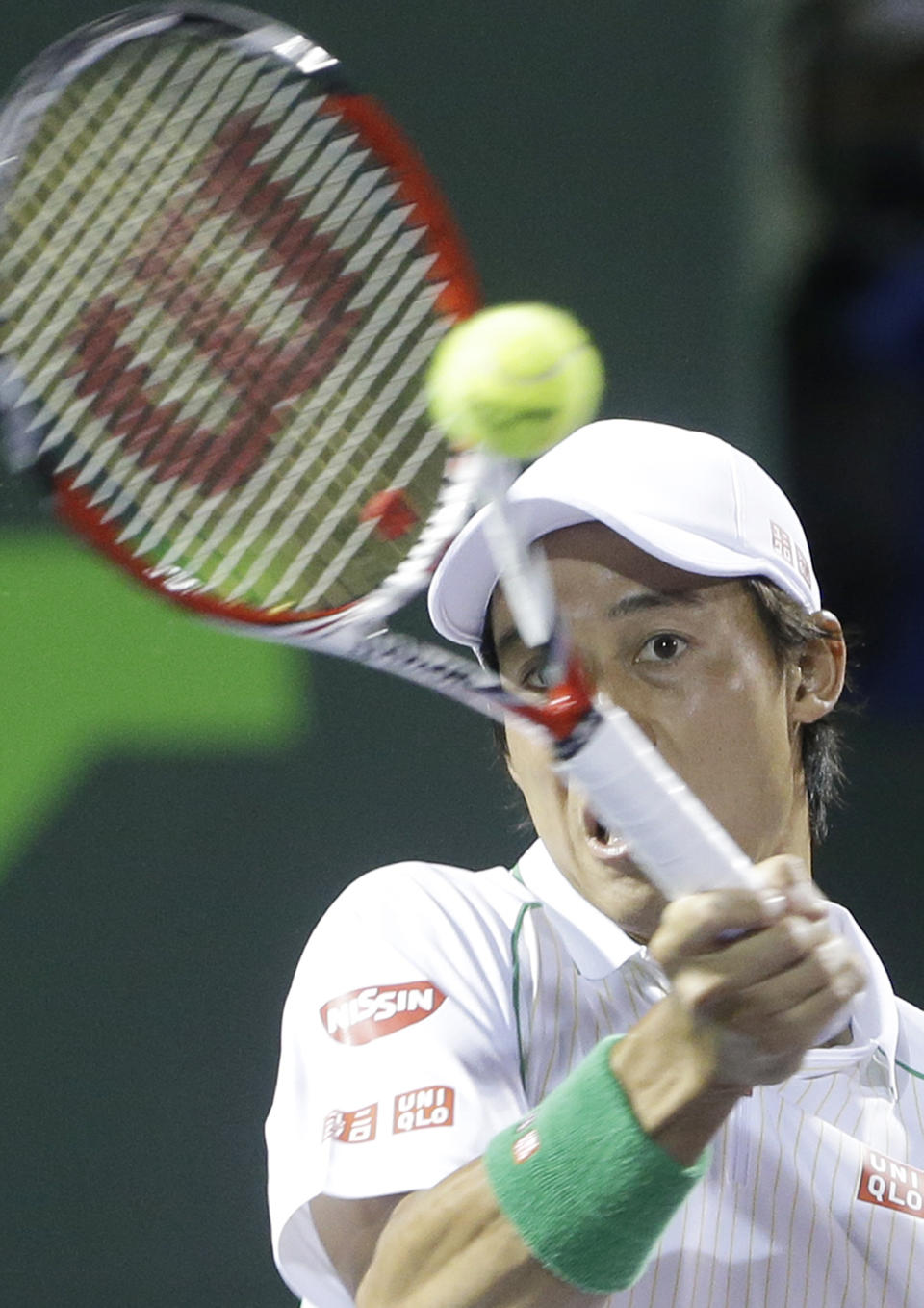 Kei Nishikori of Japan, returns a shot from Roger Federer of Switzerland, at the Sony Open Tennis tournament, Wednesday, March 26, 2014 in Key Biscayne, Fla. (AP Photo/Wilfredo Lee)