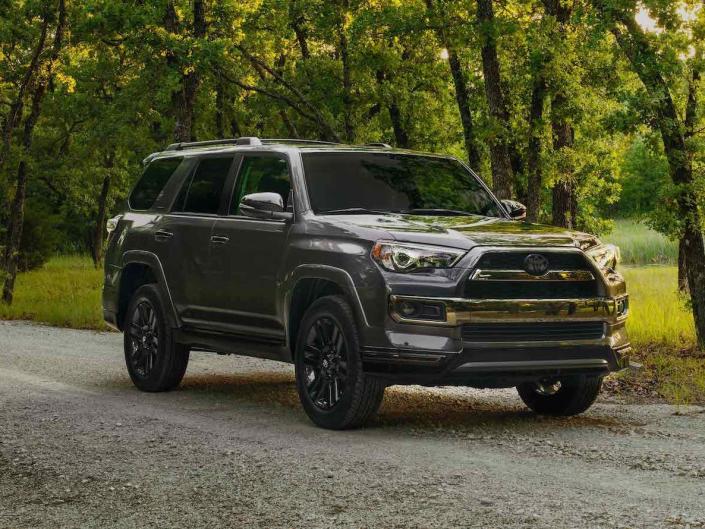 A dark-gray 2019 Toyota 4Runner on a tree-lined road.