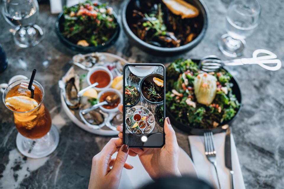 someone taking a picture of food at a table