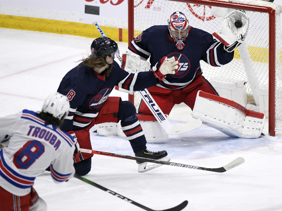 FILE - In this Feb. 11, 2020, file photo, Winnipeg Jets goaltender Connor Hellebuyck (37) makes a save on a shot from New York Rangers' Jacob Trouba (8) during first-period NHL hockey game action in Winnipeg, Manitoba. Hellebuyck has won the Vezina Trophy as top goaltender. (Fred Greenslade/The Canadian Press via AP, File)