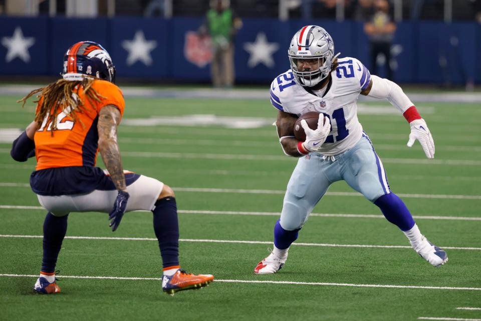 Denver Broncos cornerback Mike Ford, left, defends as Dallas Cowboys running back Ezekiel Elliott (21) looks for running room in the second half of an NFL football game in Arlington, Texas, Sunday, Nov. 7, 2021. (AP Photo/Ron Jenkins)