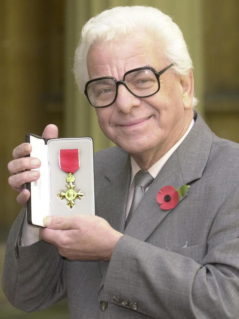 At Buckingham Palace to accept his OBE from the Queen in November 2001 (PA)