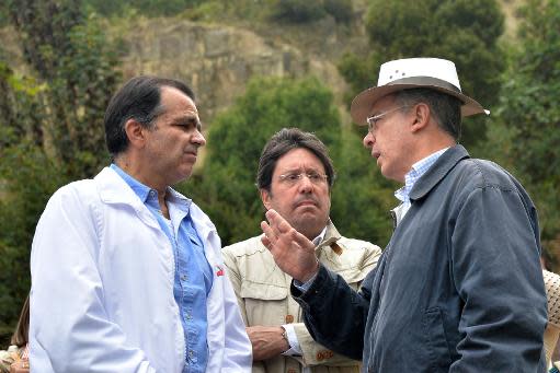 El candidato presidencial colombiano Óscar Iván Zuluaga (I) y el expresidente Alvaro Uribe (D), dialogran en presencial del ex vicepresidente Francisco Santos, durante la campaña electoral, el 10 de mayo de 2014 en Bogotá (AFP | Diana Sánchez)