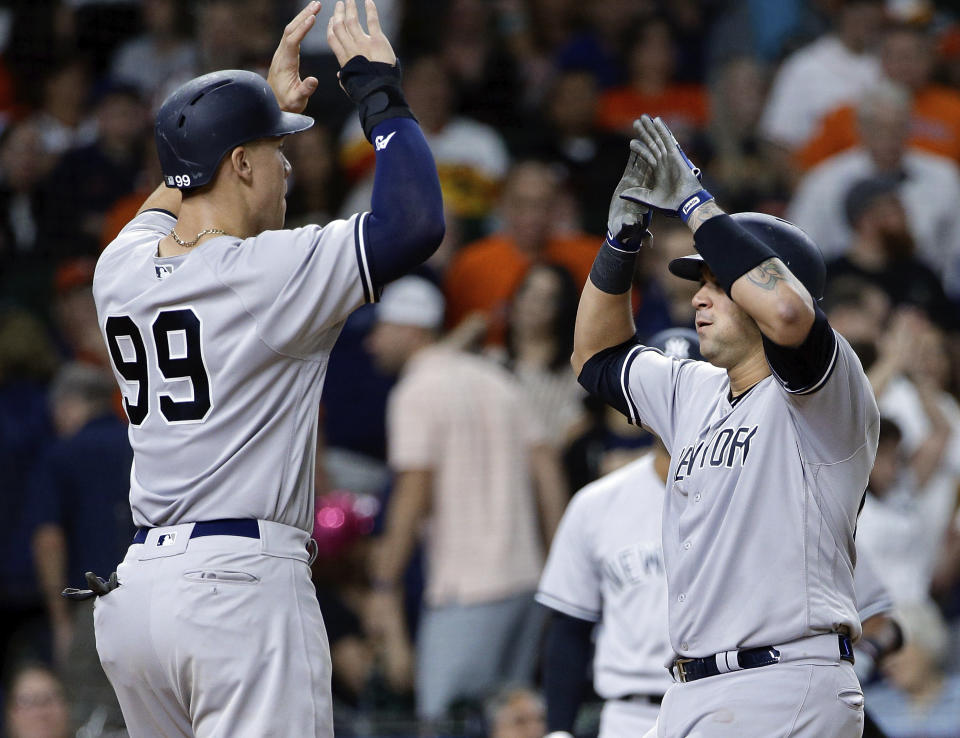 New York Yankees’ right fielder Aaron Judge (99) high fives Gary Sanchez (24) (AP Photo/Michael Wyke)