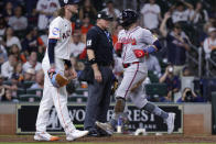 Atlanta Braves runner Adam Duvall, right, scores in front of umpire Tony Randazzo, center, and Houston Astros pitcher Josh Hader on an RBI single by teammate Orlando Arcia during the ninth inning of a baseball game Monday, April 15, 2024, in Houston. (AP Photo/Michael Wyke)