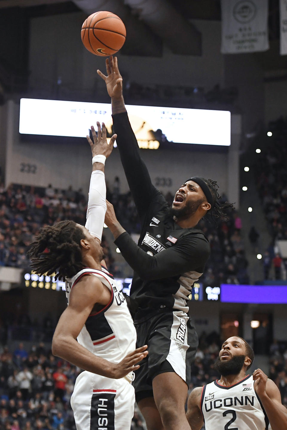 Providence's Nate Watson, right, makes a basket over Connecticut's Isaiah Whaley in the second half of an NCAA college basketball game, Saturday, Dec. 18, 2021, in Hartford, Conn. (AP Photo/Jessica Hill)